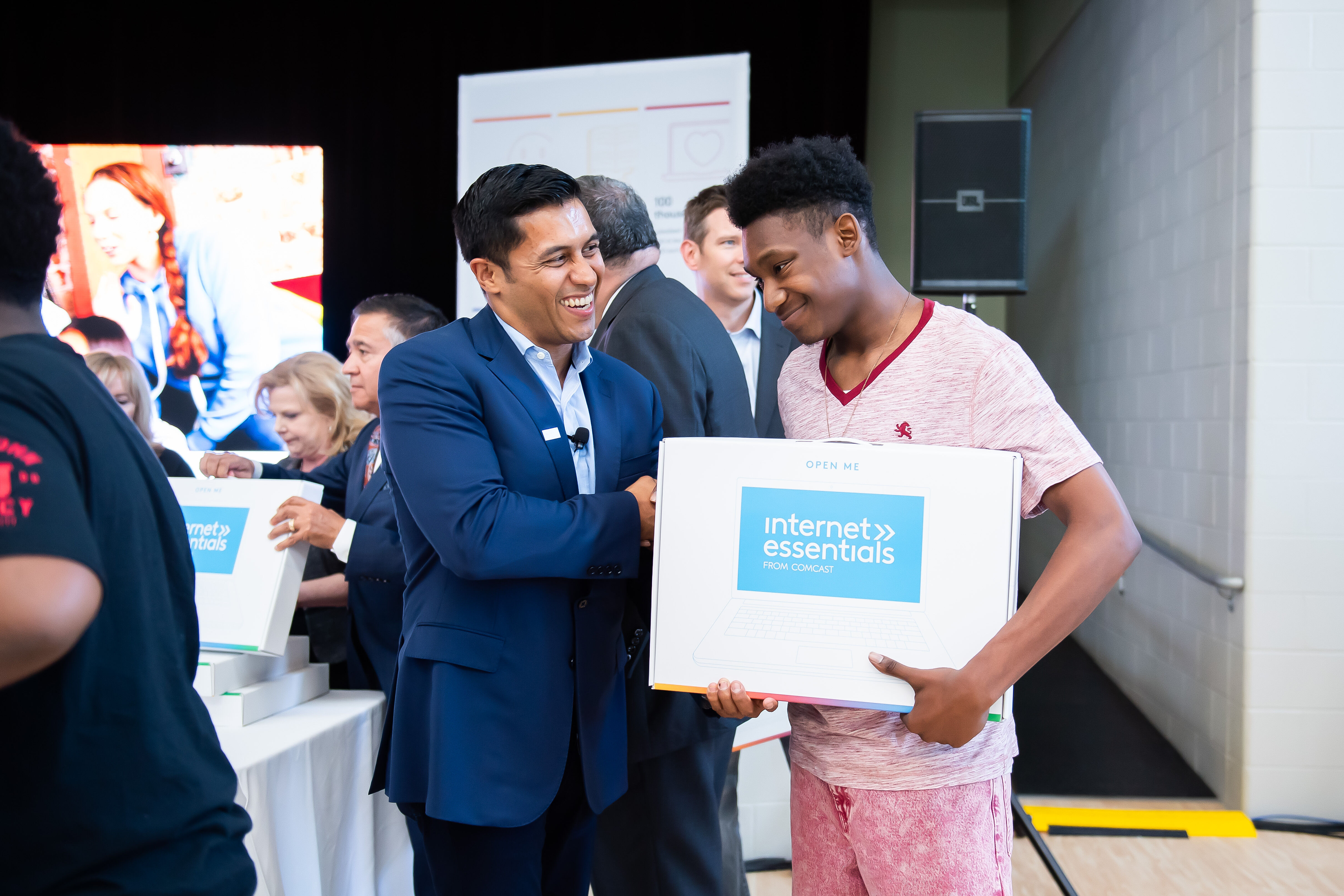 Students receive free laptops at an Internet Essentials event.