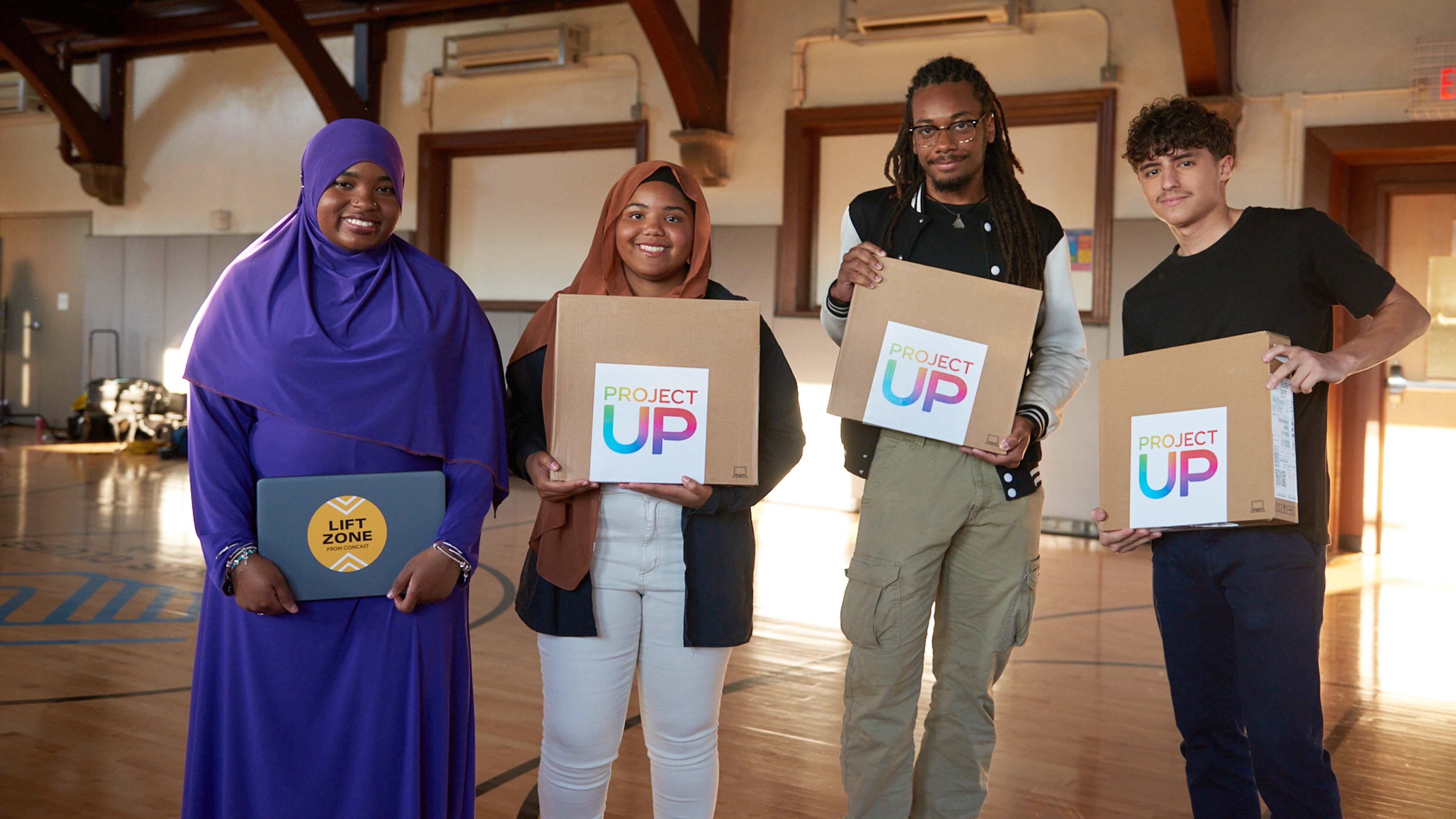 A group of students holding Project UP laptops.