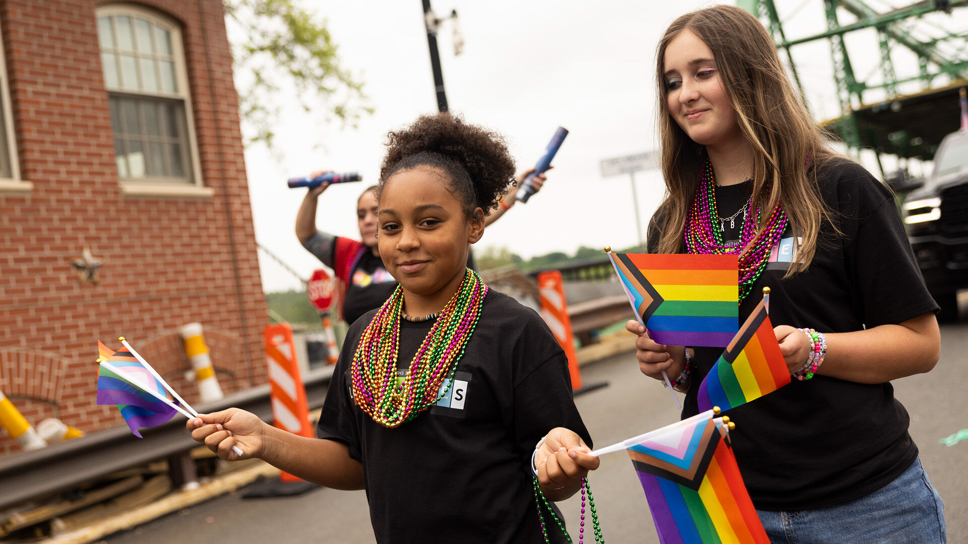 Pride parade participants holding up Pride flags.