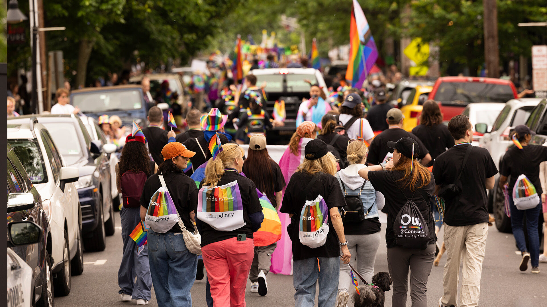 Pride parade participants holding up Pride flags.