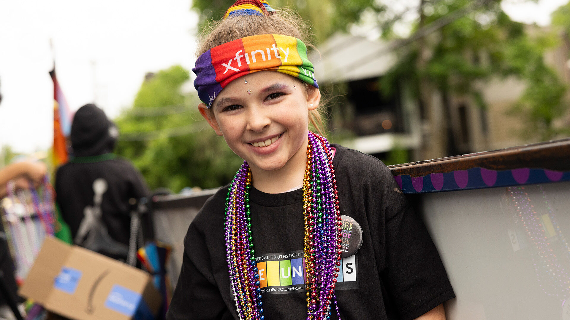 A Pride parade participant wearing a 'Love Unites' T-shirts.