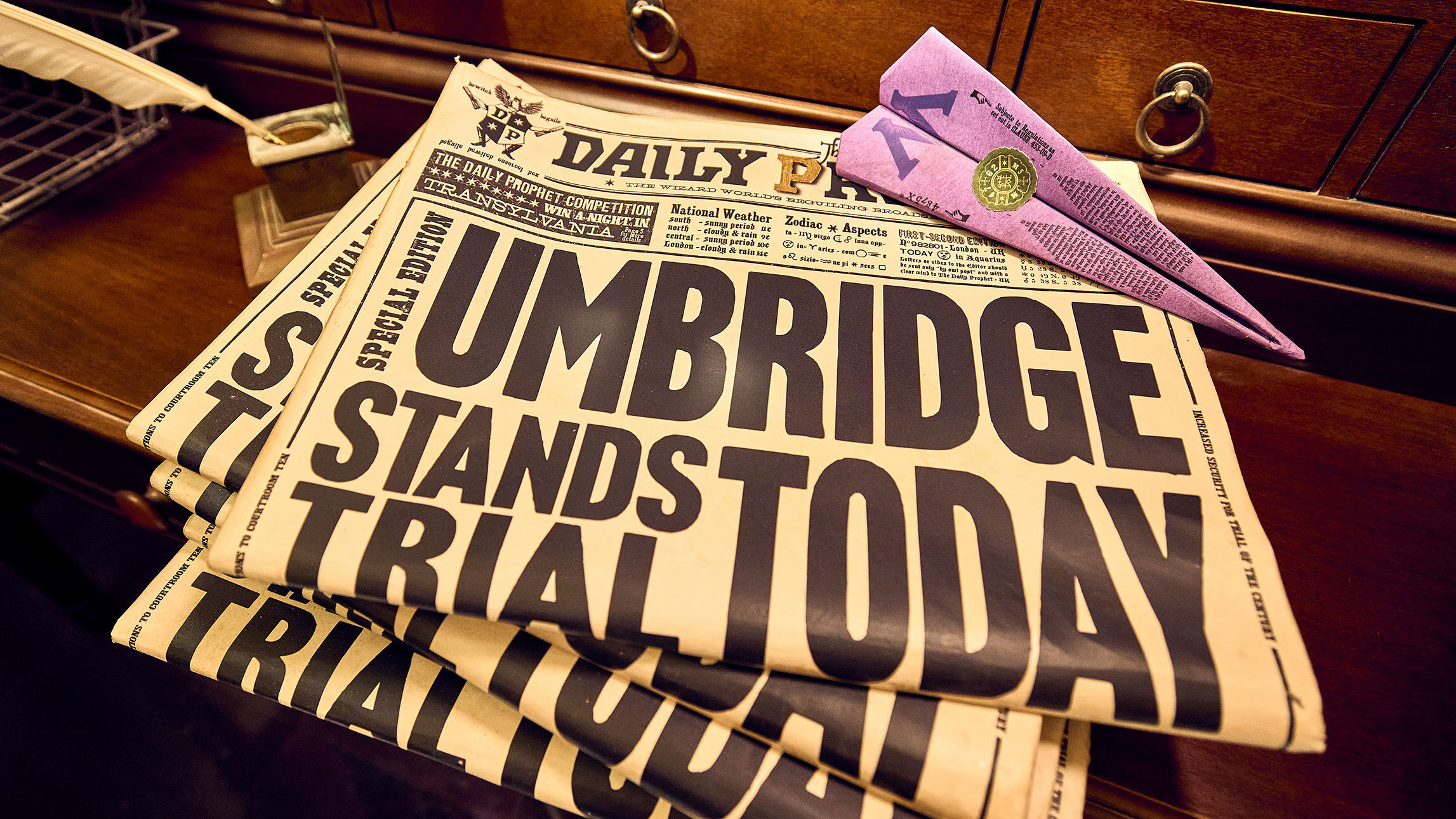 In the queue of Harry Potter and the Battle at the Ministry™ you might catch a glimpse of this stack of Daily Prophet newspapers inside a British Ministry of Magic™ reception booth. As evident by the 