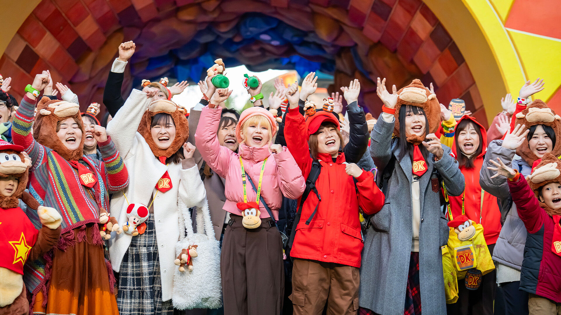 A large group of Super Nintendo World actors and team members waving during the Grand Opening Ceremony